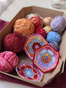 Crocheted hexagon motifs with pink, blue, and red thread